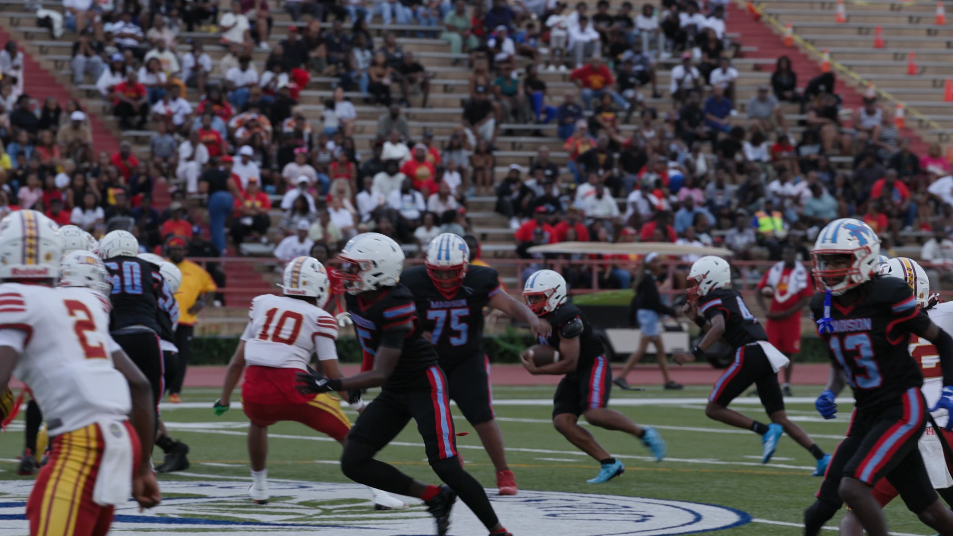 Madison football players, photographed from the sidelines.